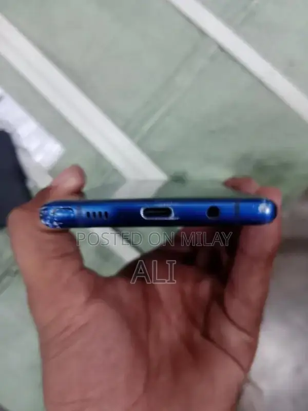 Samsung Smartphone with Cracked Back Glass and Original Accessories