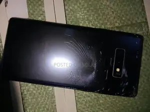 Samsung Smartphone with Cracked Back Glass and Original Accessories