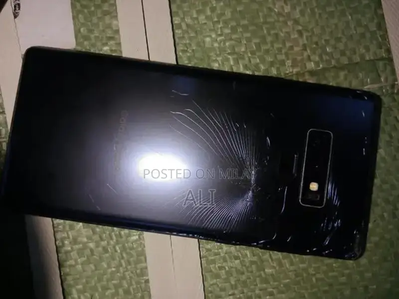 Samsung Smartphone with Cracked Back Glass and Original Accessories
