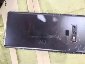 Samsung Smartphone with Cracked Back Glass and Original Accessories